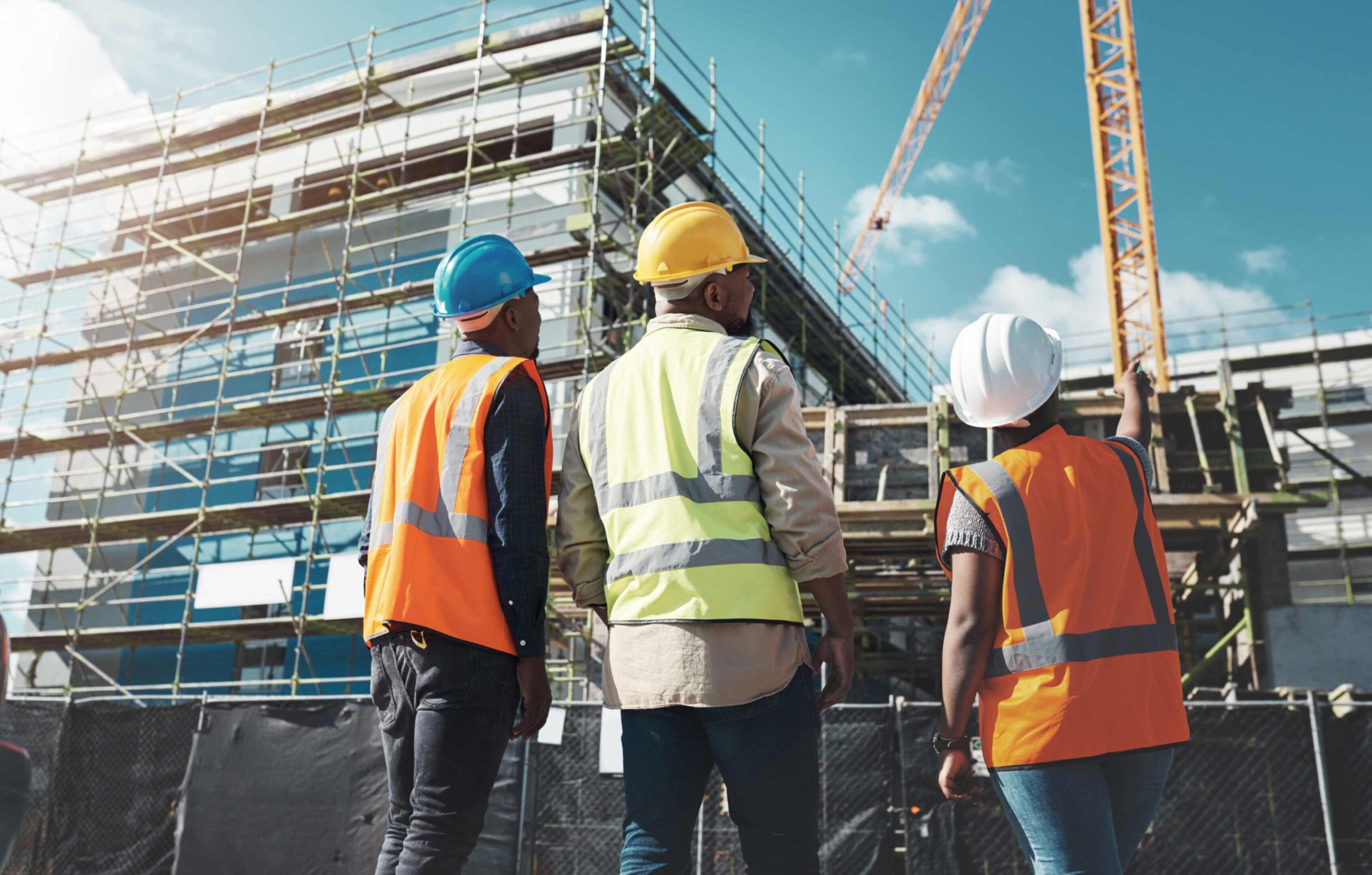 Construction workers observing building site progress.