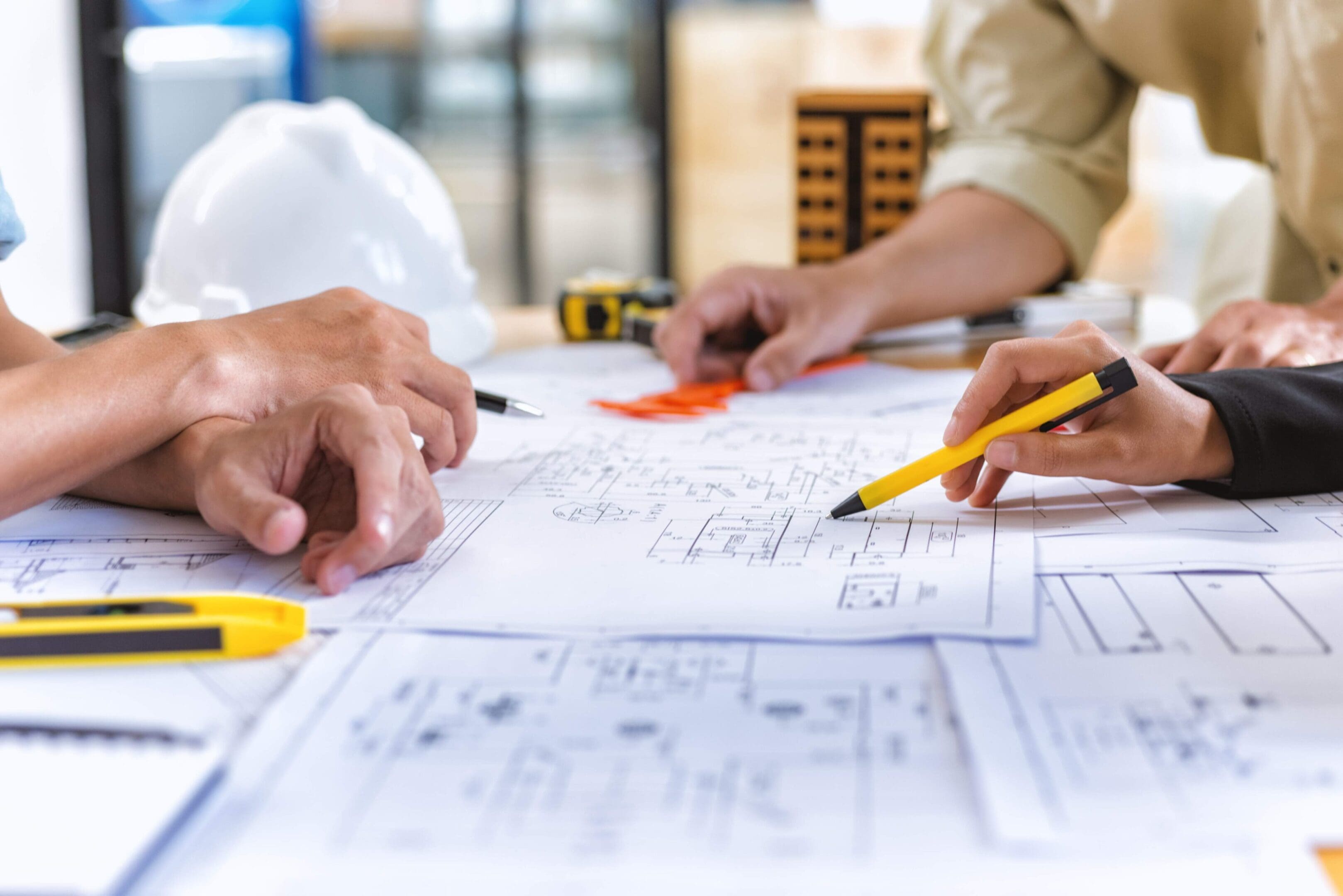 Architects reviewing blueprints at a desk.