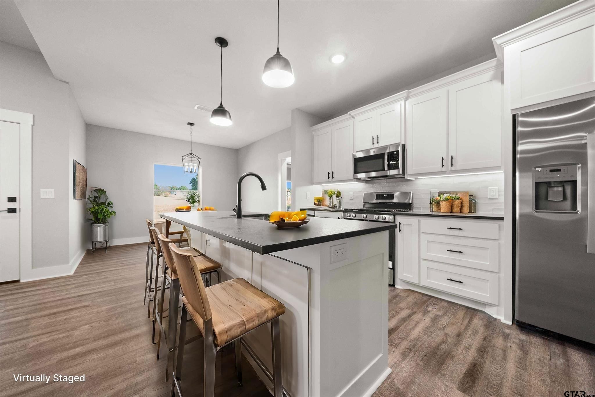 Modern kitchen with white cabinets and a large island with bar stools.