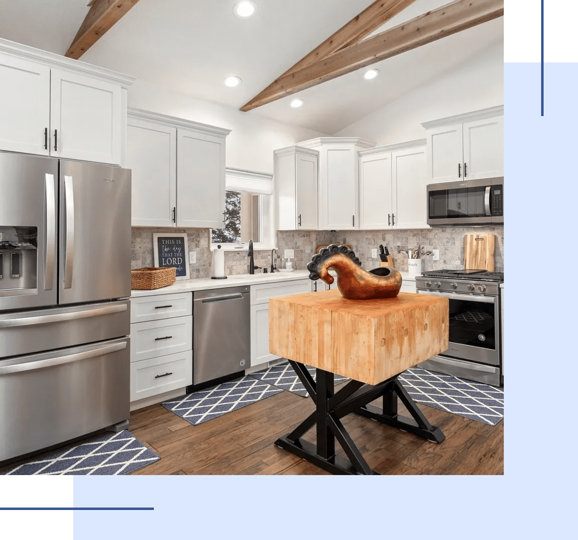 Modern kitchen with white cabinets and a central butcher block island.