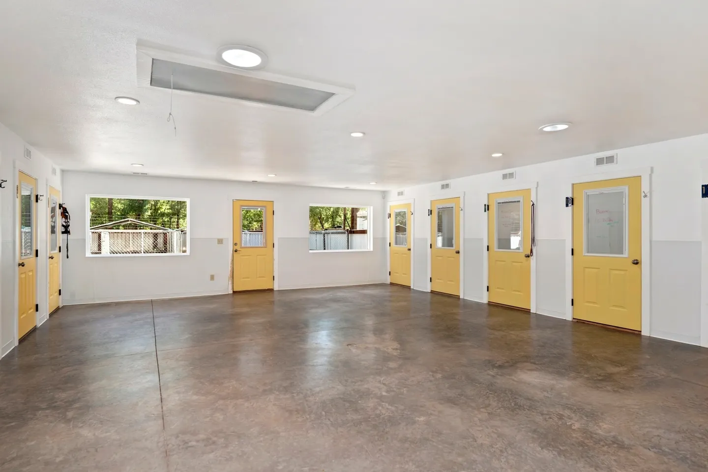 Empty room with yellow doors and large windows.