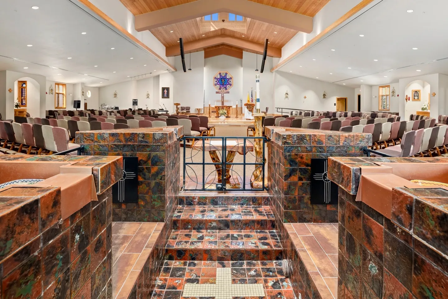 Interior view of a modern church with wooden ceiling and marble steps.