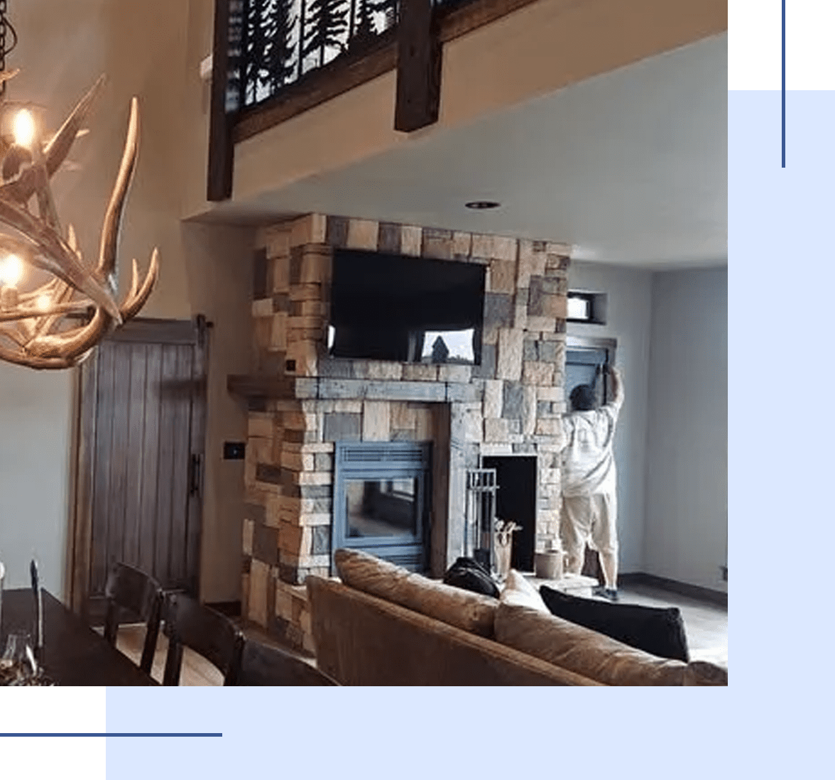 Cozy living room with stone fireplace and mounted antlers.