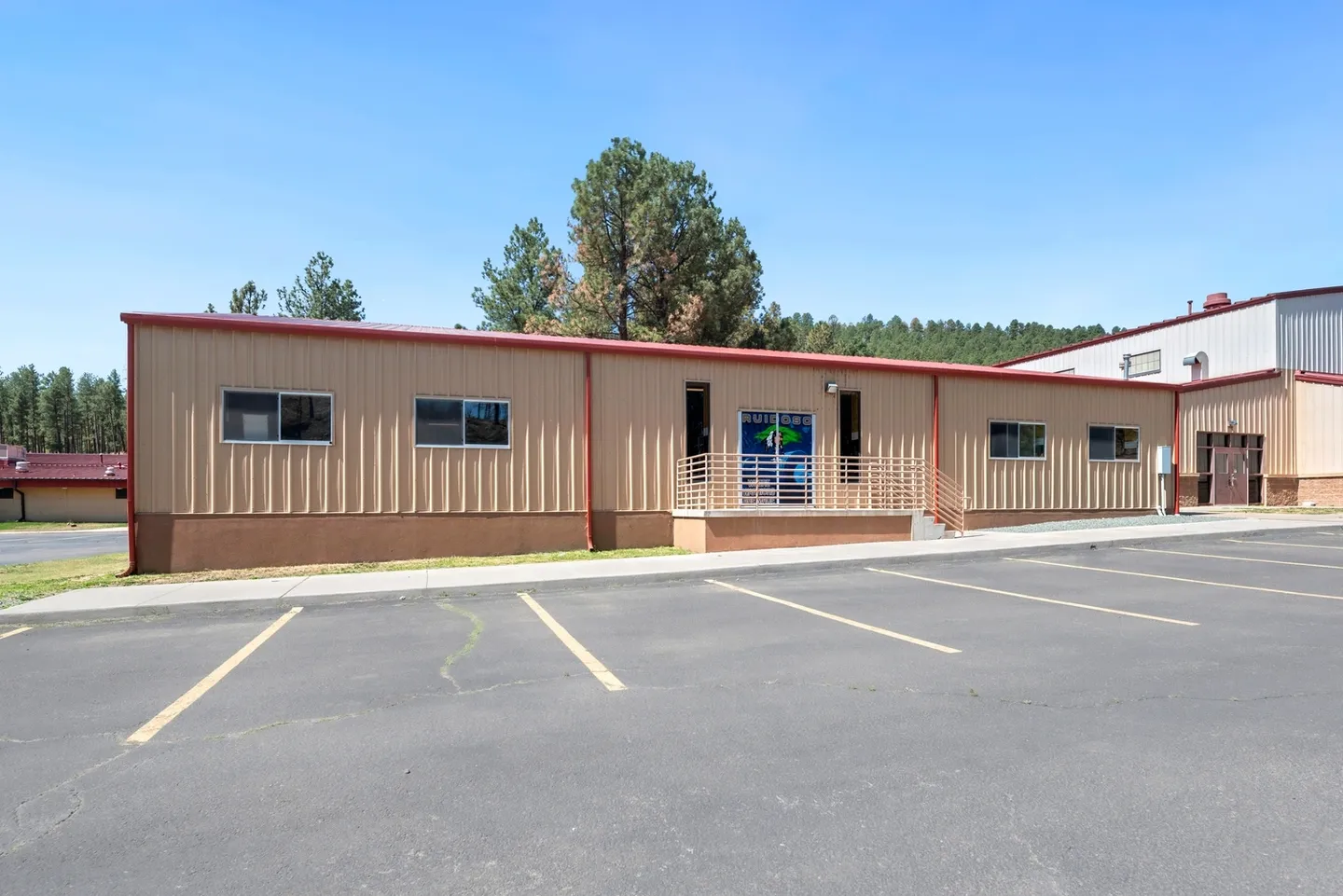Single-story building with a fenced entrance and parking lot in front.