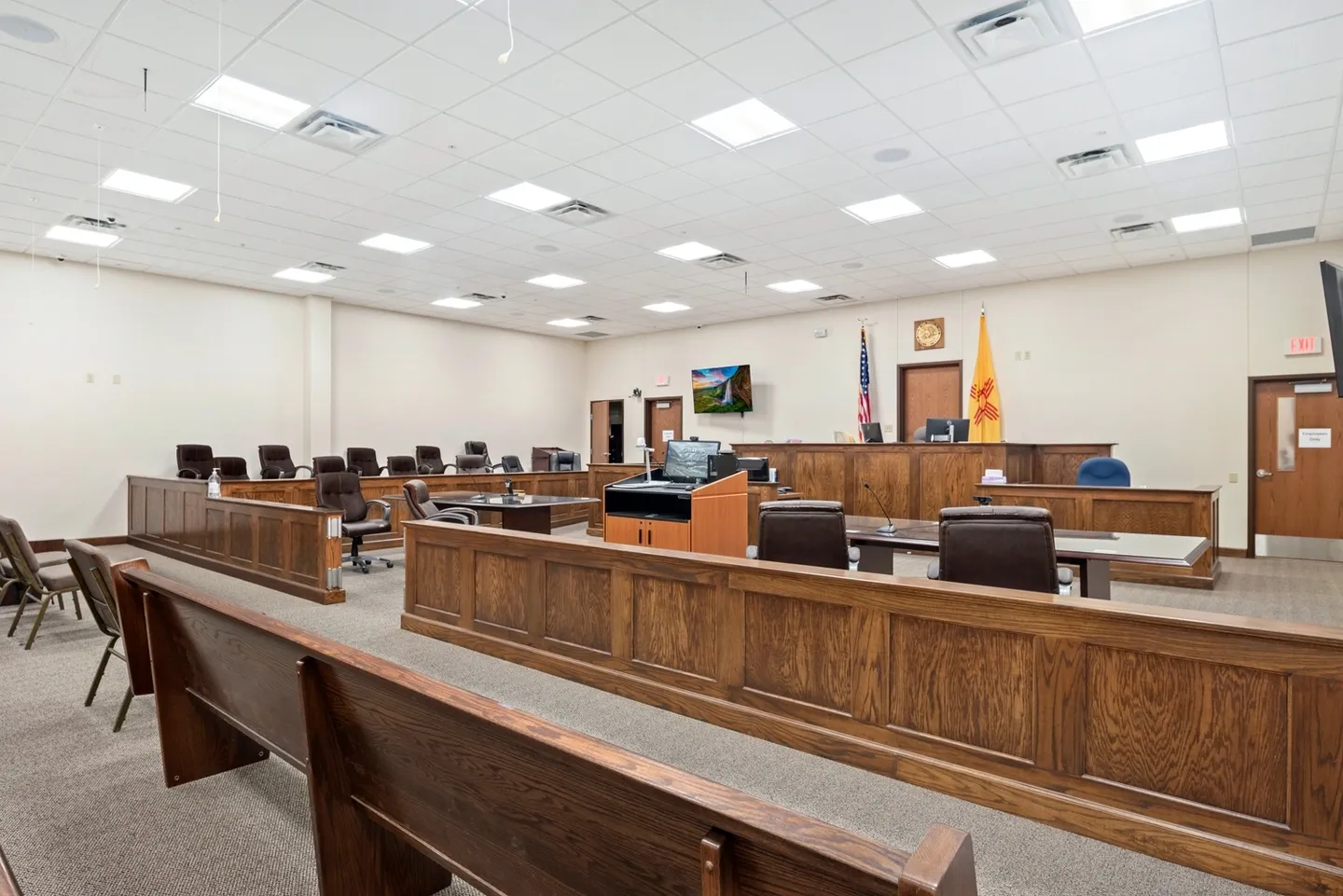 Empty courtroom with wooden benches and judge's bench.