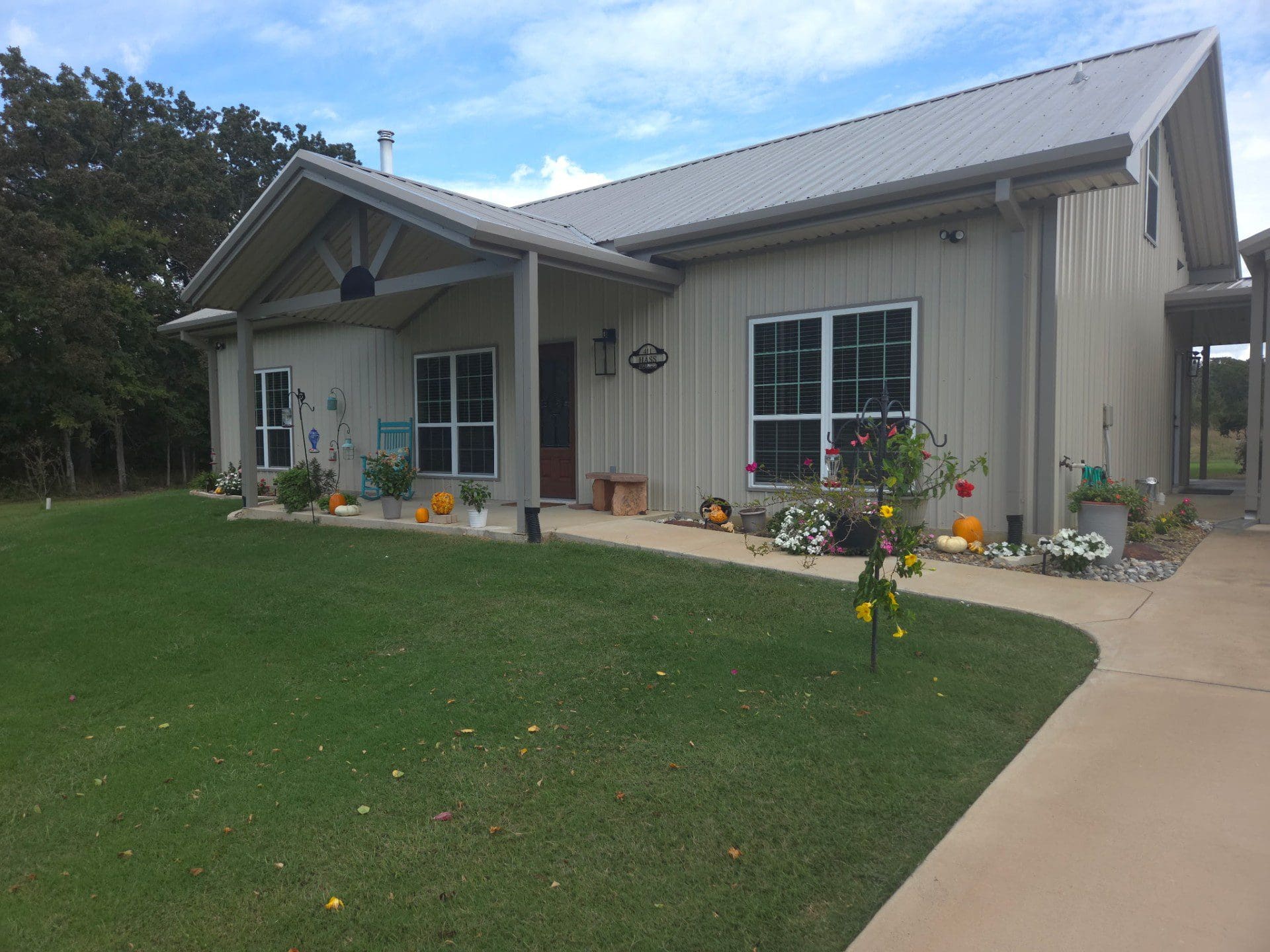 Single-story house with a well-kept lawn and potted plants near the entrance.