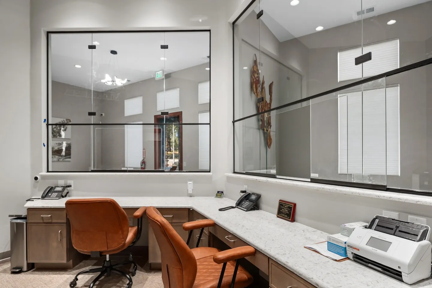 Modern office workspace with brown chairs and large mirrors.