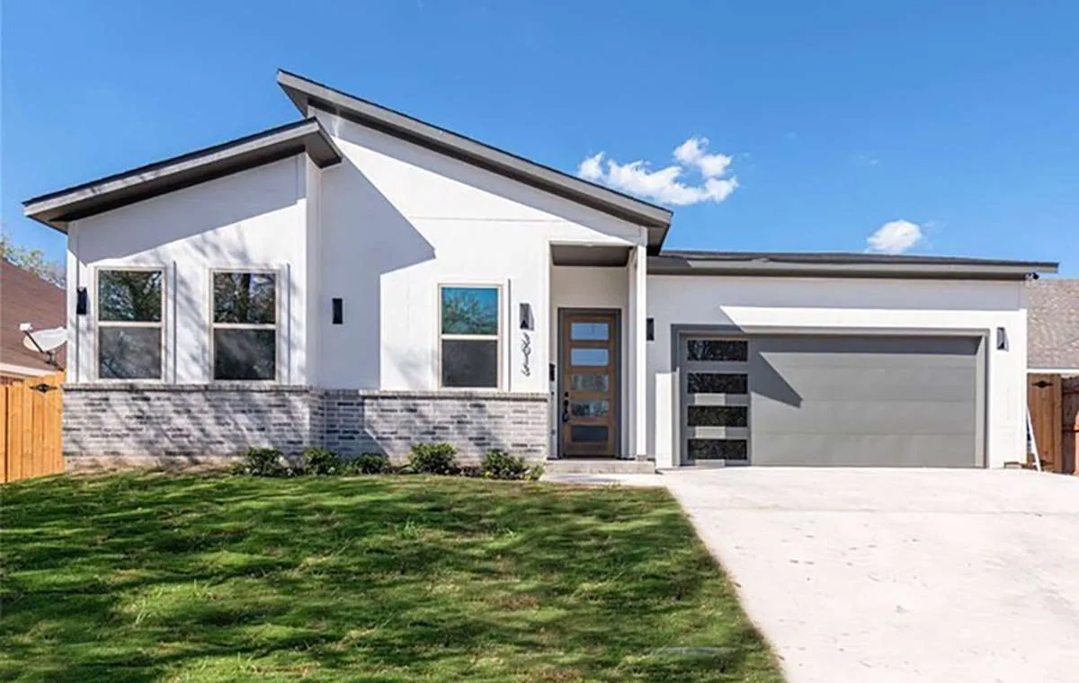 Modern white house with stone accents and a two-car garage.