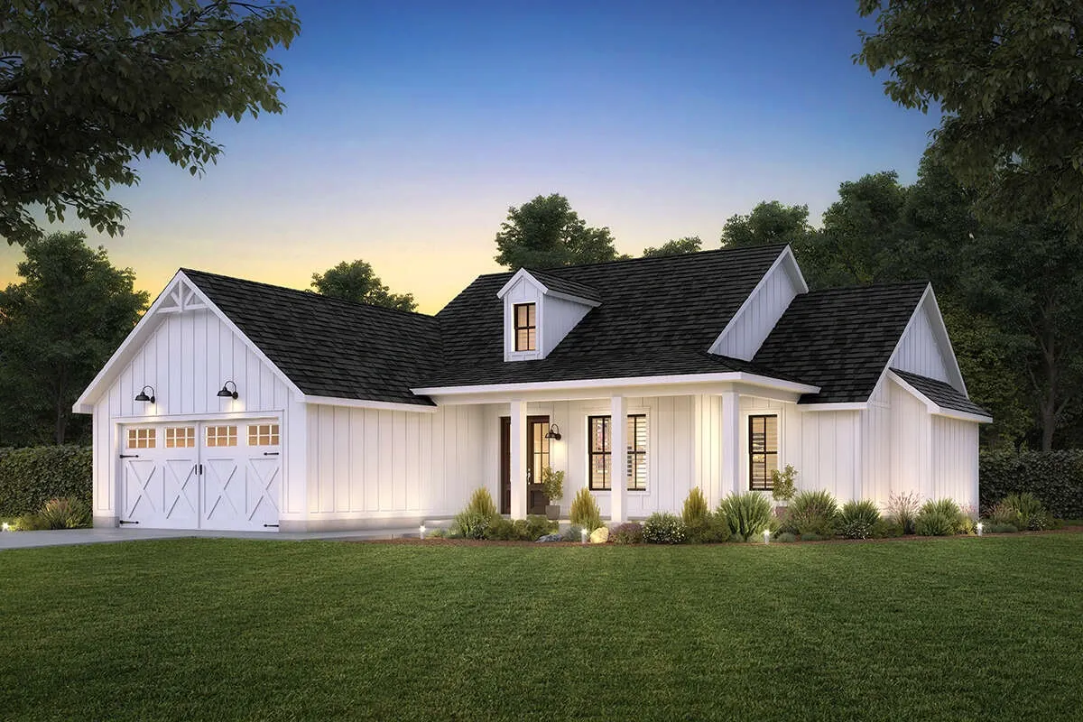 Elegant white farmhouse-style home with manicured lawn at dusk.