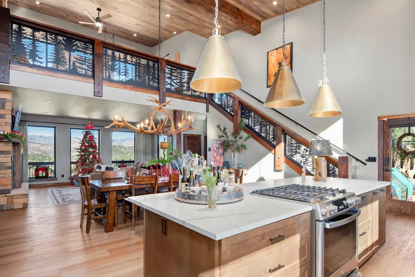 Cozy kitchen with wooden beams, pendant lights, and a festive Christmas tree.