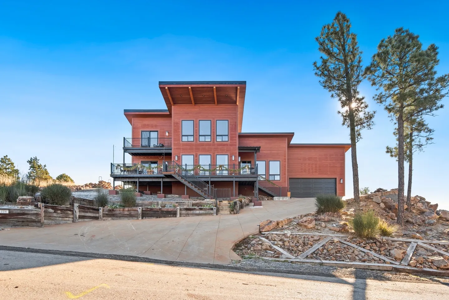 Modern multi-level house with large windows and spacious balconies.