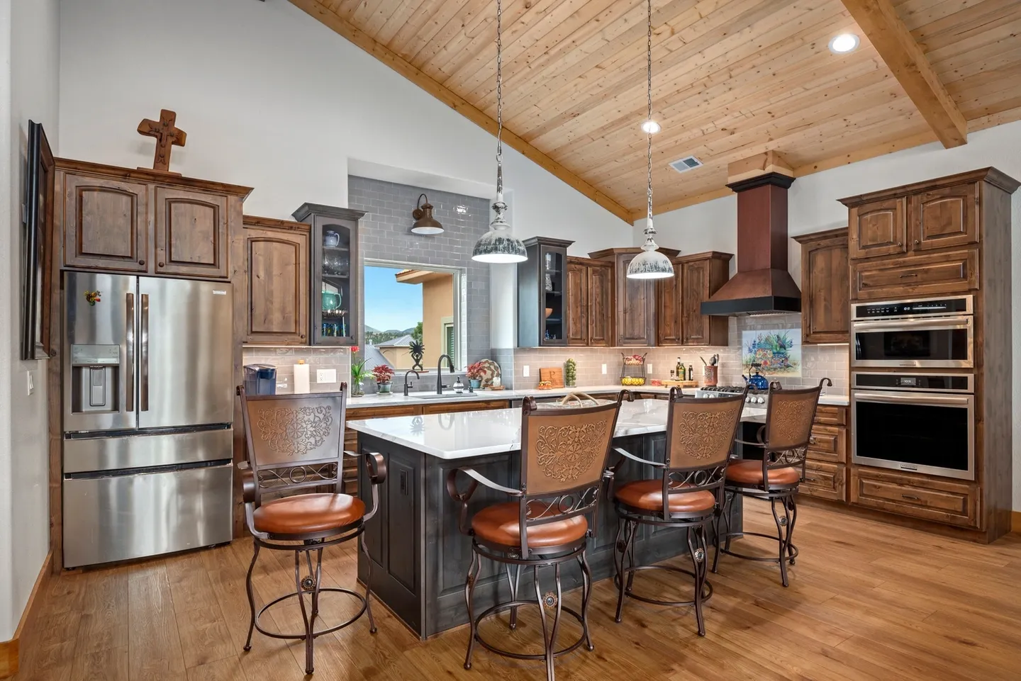Spacious kitchen with wooden ceiling and island seating.