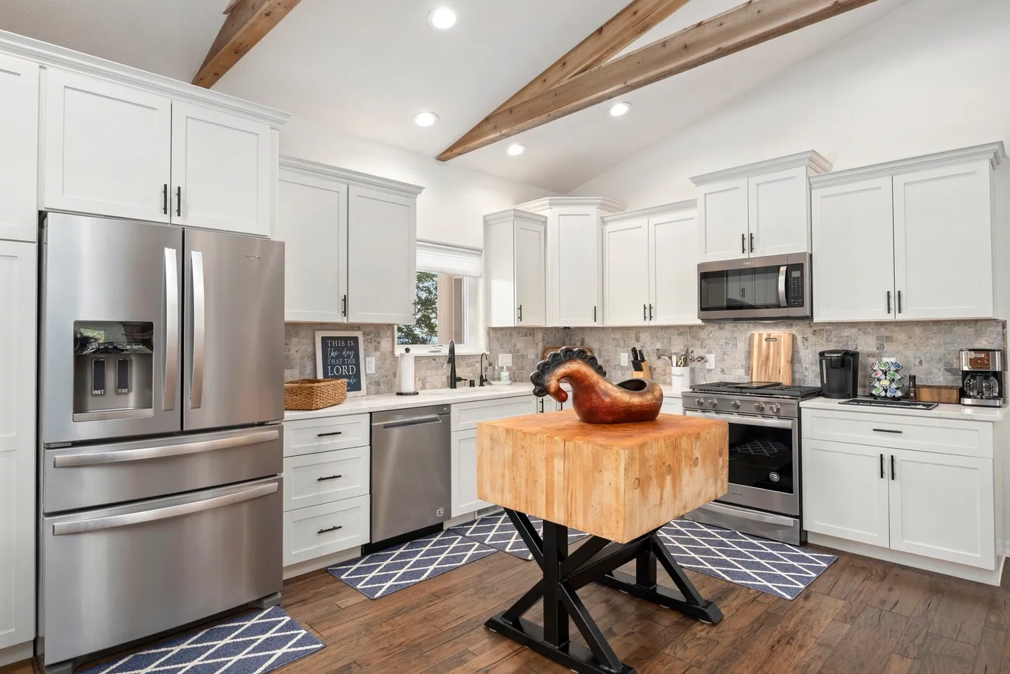 Modern kitchen with wooden beams and a large island.