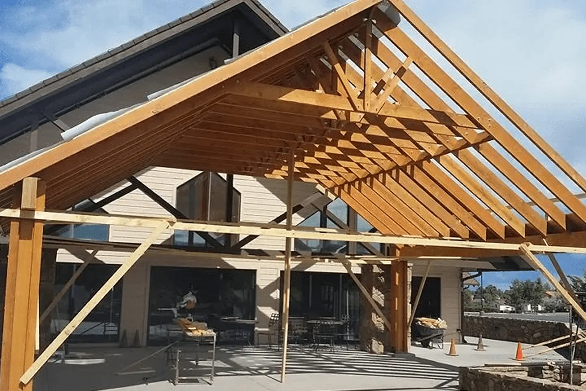 Wooden roof framework under construction with visible beams and supports.