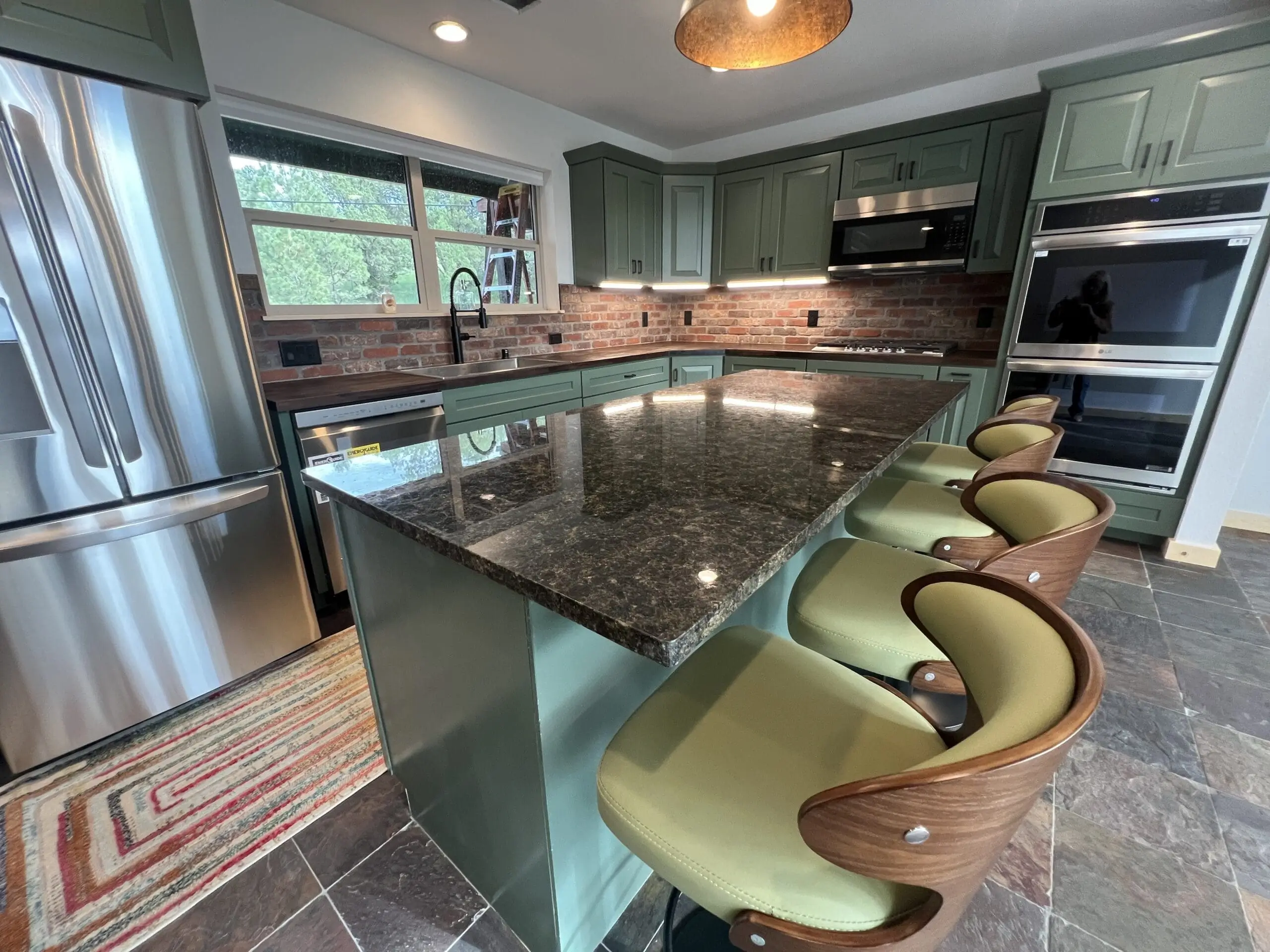 Modern kitchen with granite island and stylish bar stools.